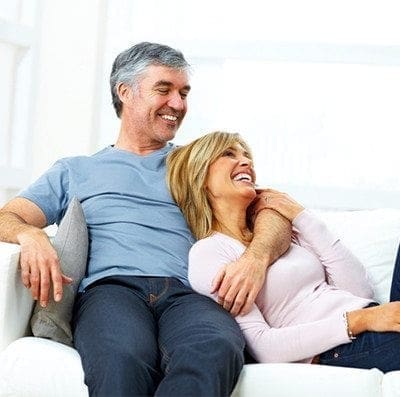 Elderly couple sitting in a sofa talking about water heaters