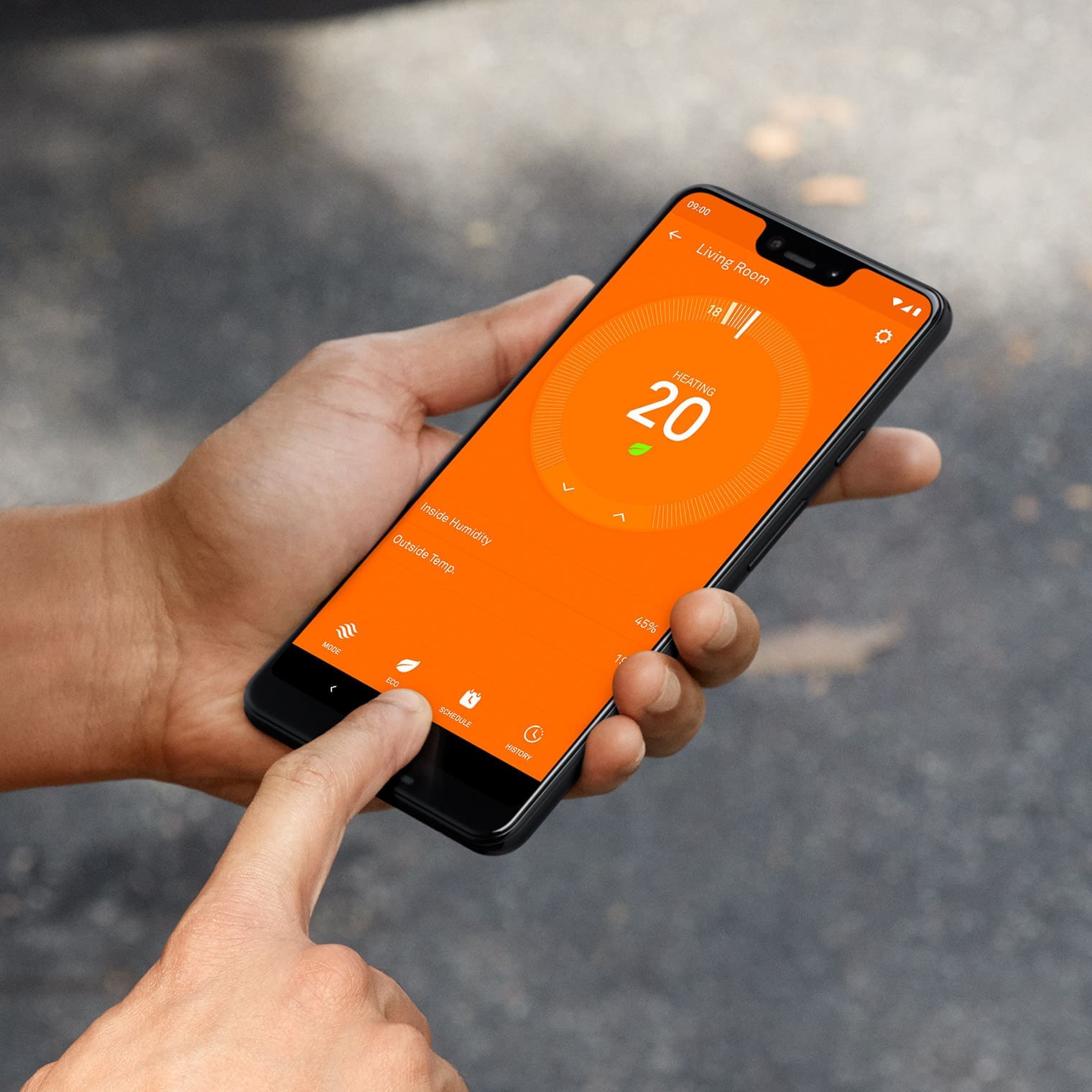 Hand holds phone looking at temperature setting for Nest Learning Thermostat